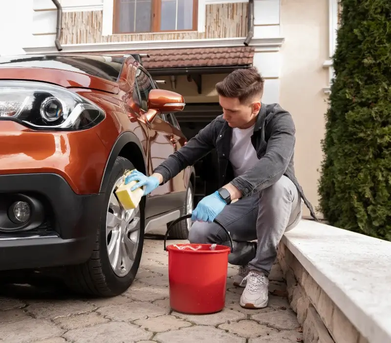 Lavage auto à domicile Ville-Houdlémont : professionnel intervenant sur un véhicule